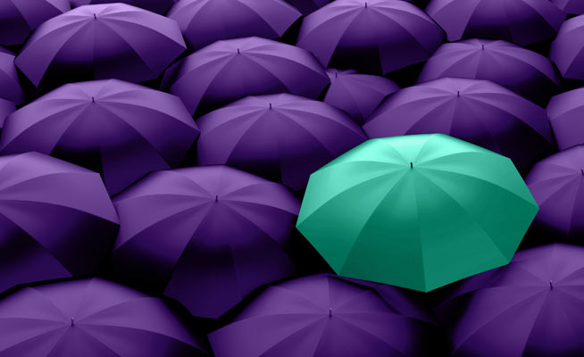 group of purple umbrellas with one teal umbrella in the middle